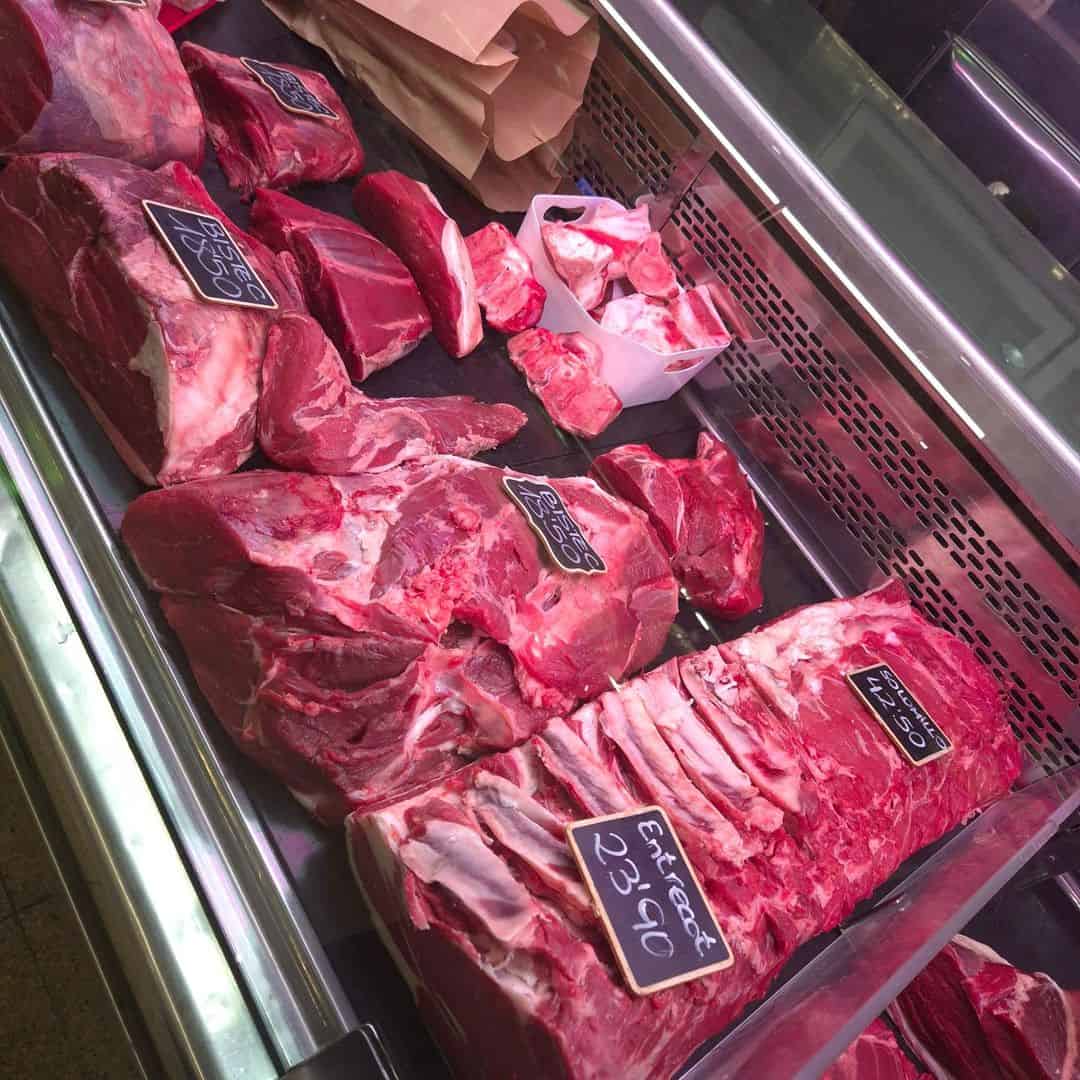 Variedad de carnes en mostrador de carnicería.