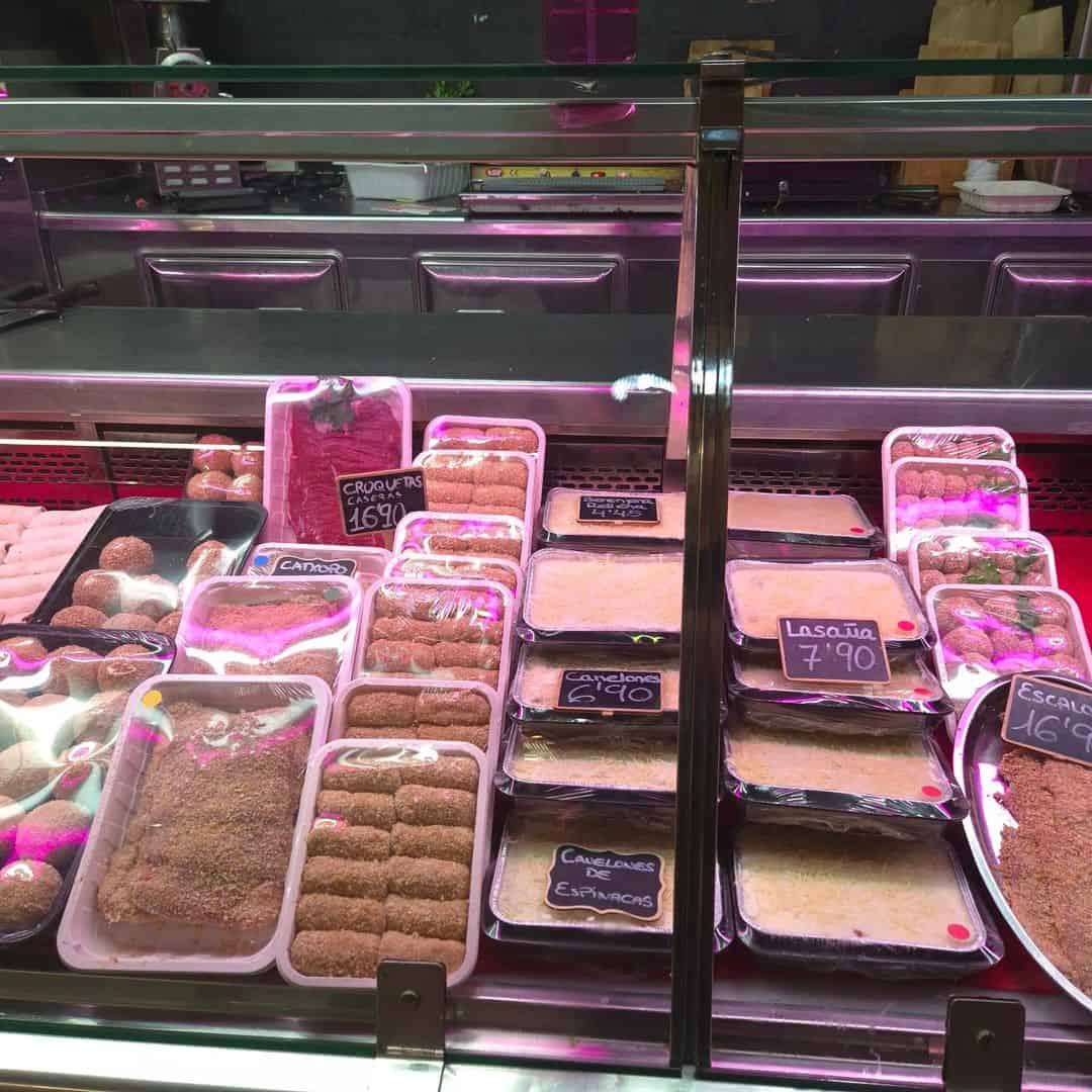 Vitrina con alimentos empacados y etiquetados en supermercado.